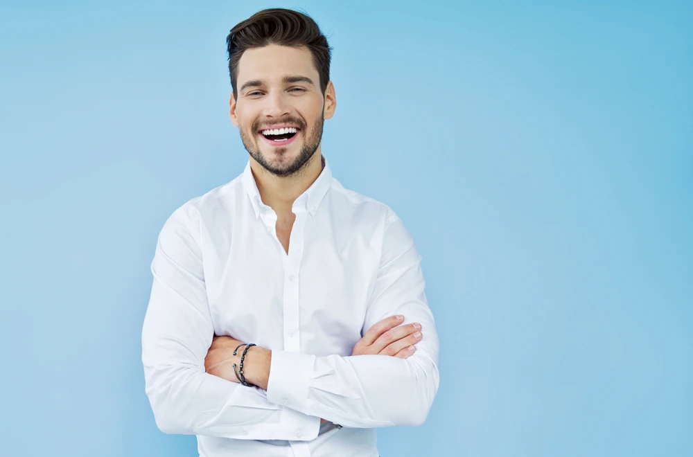 Man wearing white tshirt smiling with dental veneers