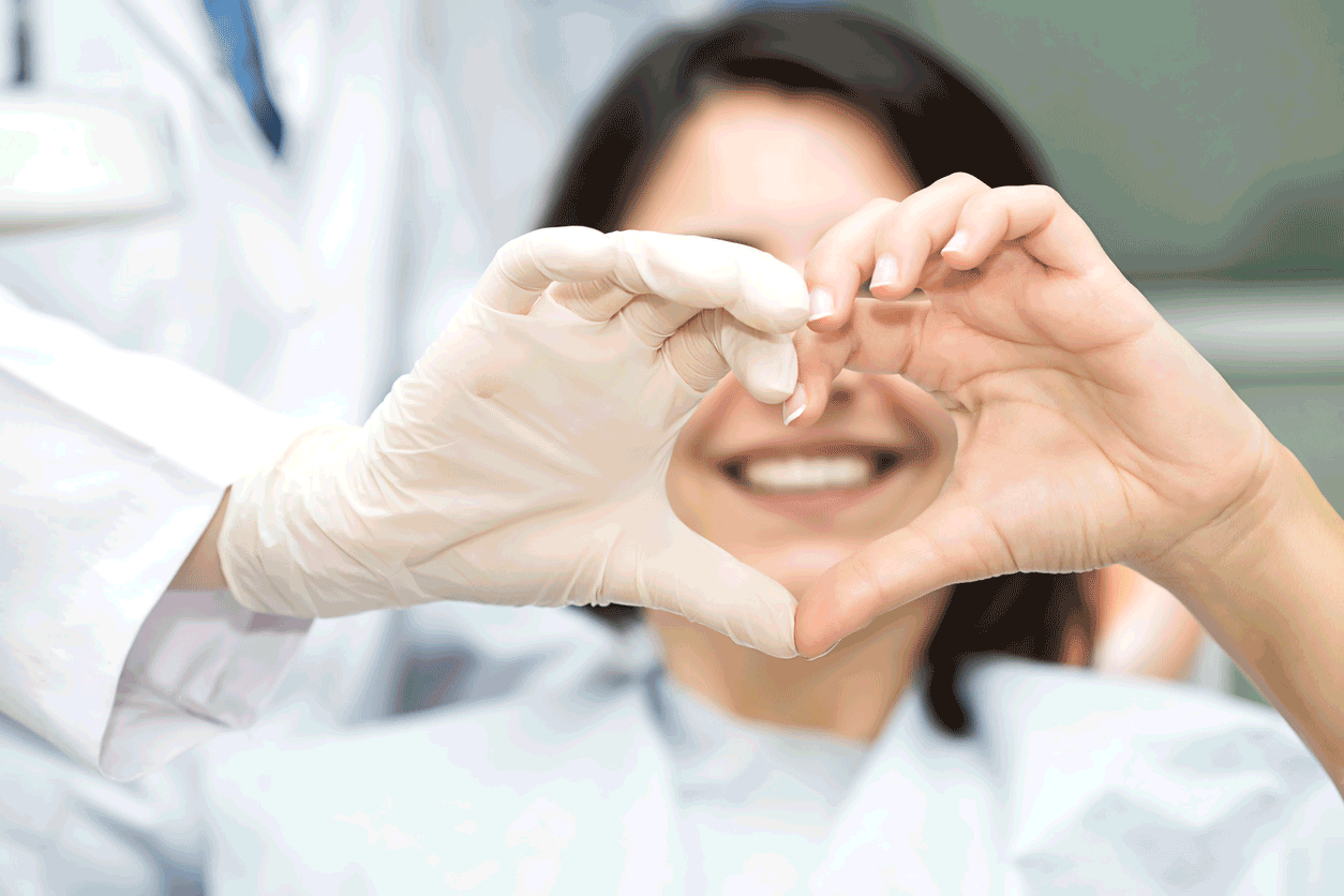 Dentist and patient making love heart shape with hands