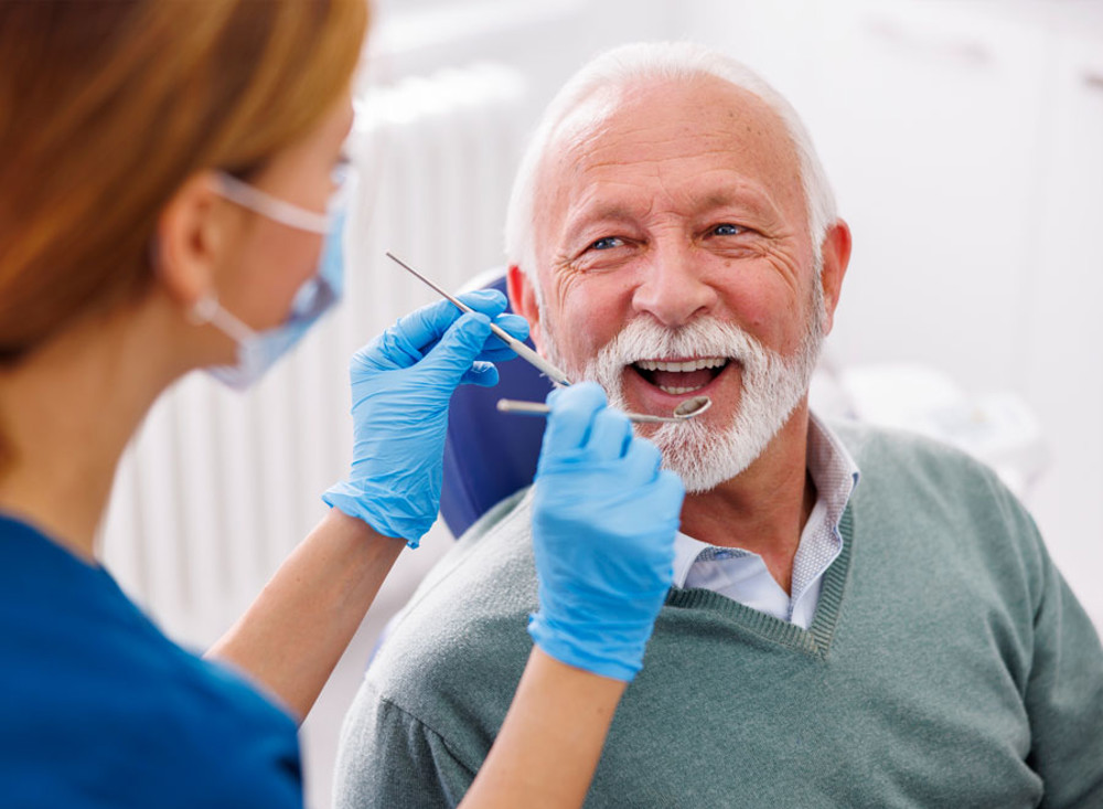 Mature aged man sitting in dental chair or oral cancer screening 