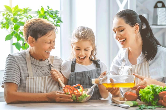 Family laughing while cooking a healthy dinner together