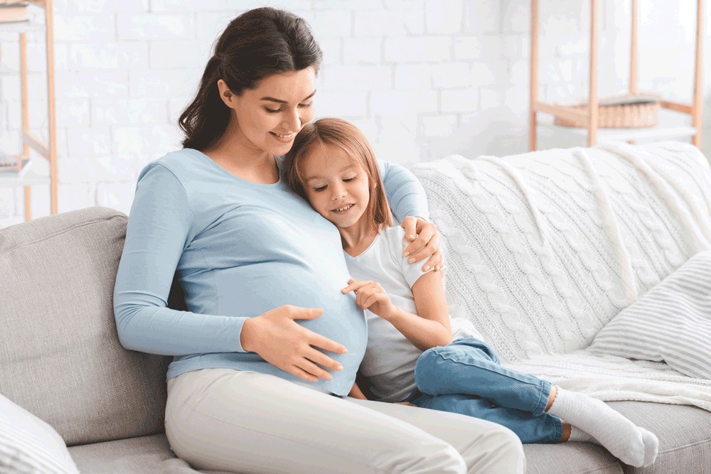 Pregnant woman and daughter sitting together