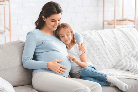 Pregnant woman and daughter sitting together