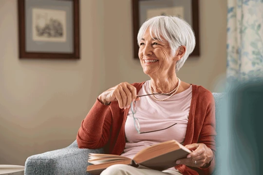 Mature aged woman reading book and smiling 