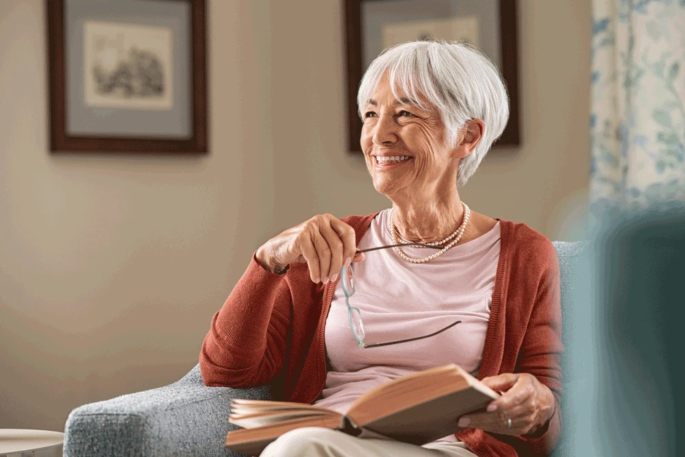 Mature aged woman reading book and smiling 